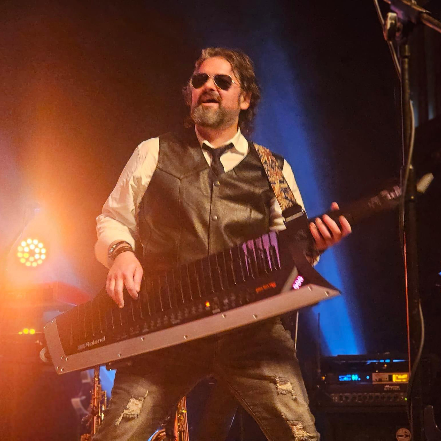 Andrew Doss performing on a rock stage, playing a keytar